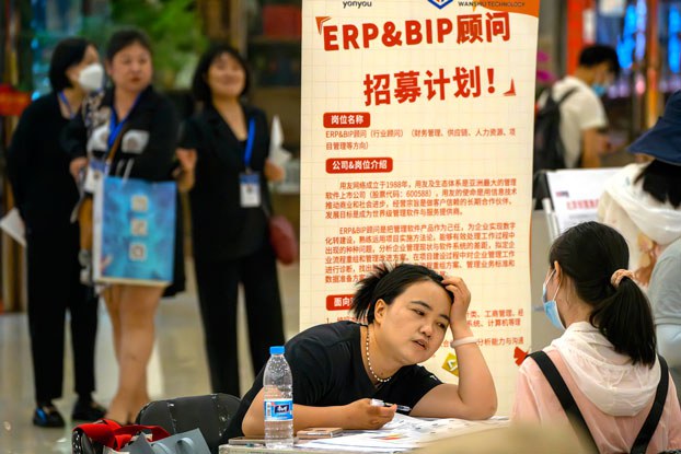 ENG_CHN_EconomicWoes_11292023.3.jpg A recruiter talks with an applicant at a booth at a job fair at a shopping center in Beijing, China, on June 9, 2023. (Mark Schiefelbein/AP)