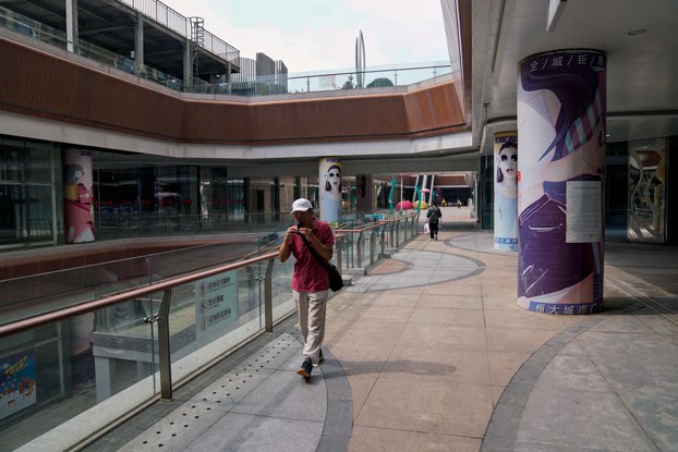ENG_CHN_EconomicWoes_11292023.4.jpg A man plays a harmonica while walking by a deserted Evergrande city plaza in Beijing, China, on Sept. 18, 2023. (Andy Wong/AP)