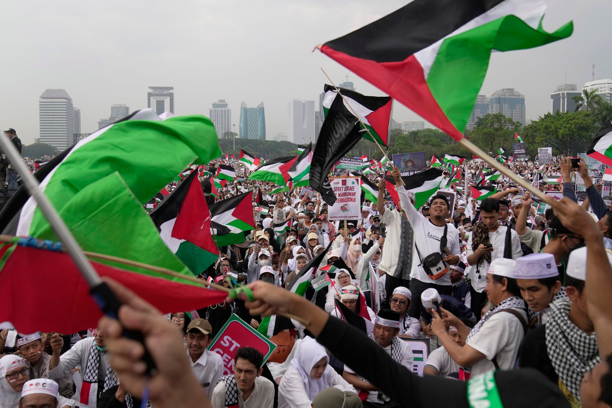Protesters shout slogans and wave Palestinian flags during a rally in Jakarta on Sunday. Photo: AP