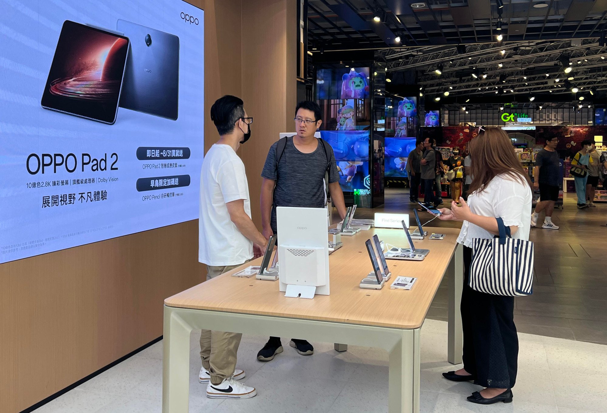 Staff at a Taipei Oppo store explain new phones and tablets to customers. Photo: Ralph Jennings