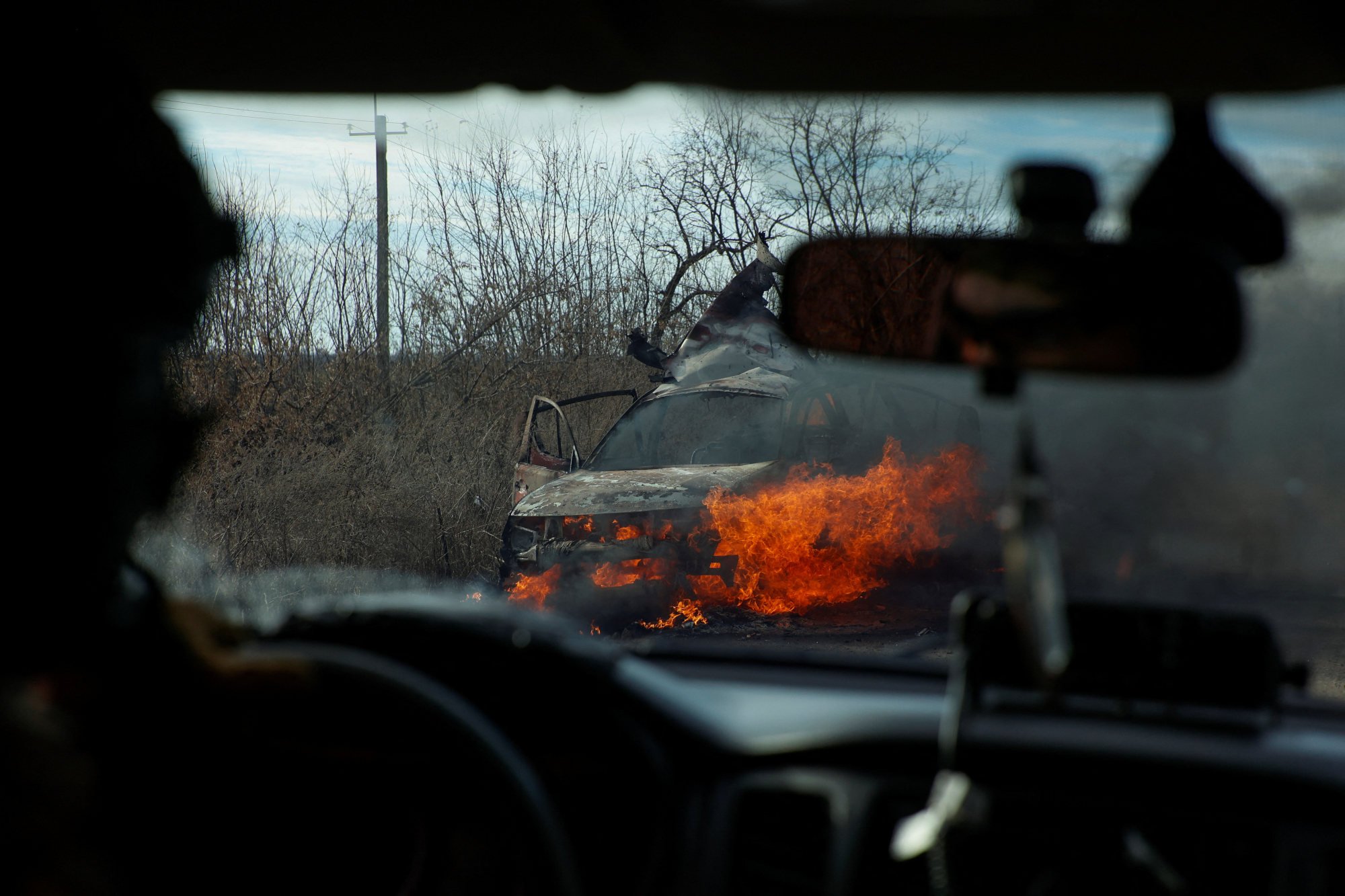 Ukrainian servicemen move past a burning car outside the town of Avdiivka amid Russia’s attack in the Donetsk region on Wednesday. The EU aims to blacklist companies that have been helping Moscow on the battlefield. Photo: Radio Free Europe/Radio Liberty via Reuters