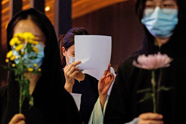 ENG_CHN_HKNatSec_11302023.3.jpg A woman holds a white sheet of paper during a protest over COVID-19 restrictions in mainland China, during a commemoration of the victims of a fire in Urumqi, in Hong Kong, Nov. 28, 2022. (Tyrone Siu/Reuters)