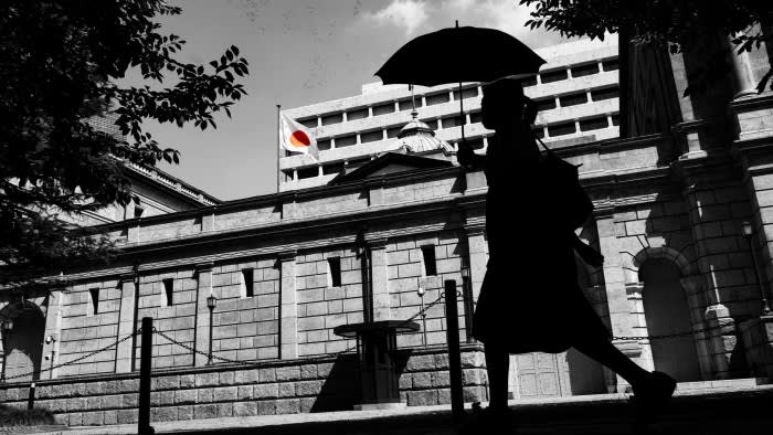 A pedestrian walks past the Bank of Japan building in Tokyo