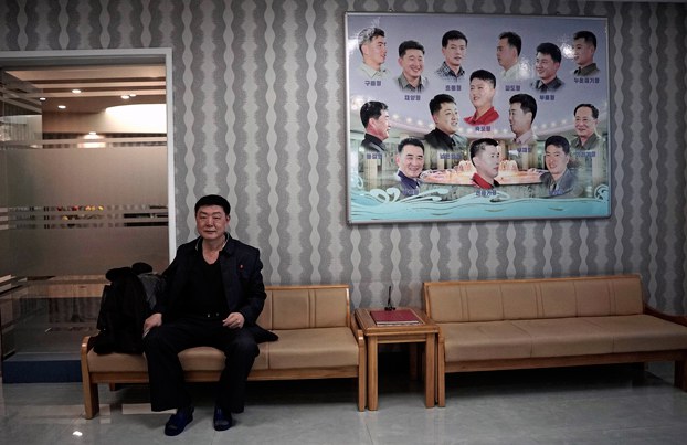 2_ENG_KOR_HairLossTreatment_11182023_02.jpg A North Korean man waits outside a barber shop next to a poster with different types of hairstyles in Pyongyang in 2015. Credit: Wong Maye-E/AP