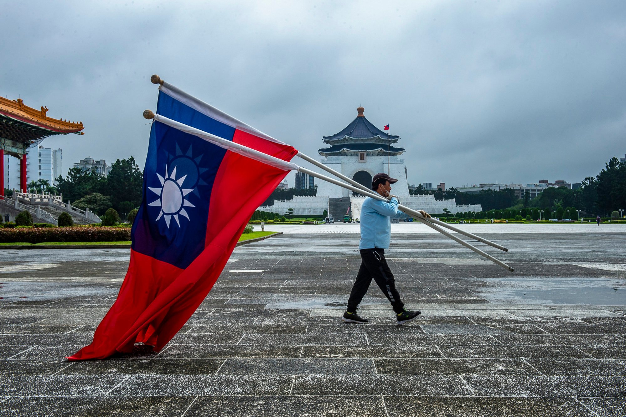 A man carries flags of the Republic of China in Freedom Square in front of the Chiang Kai-shek Mausoleum in Taipei. Photo: ZUMA Press Wire/dpa