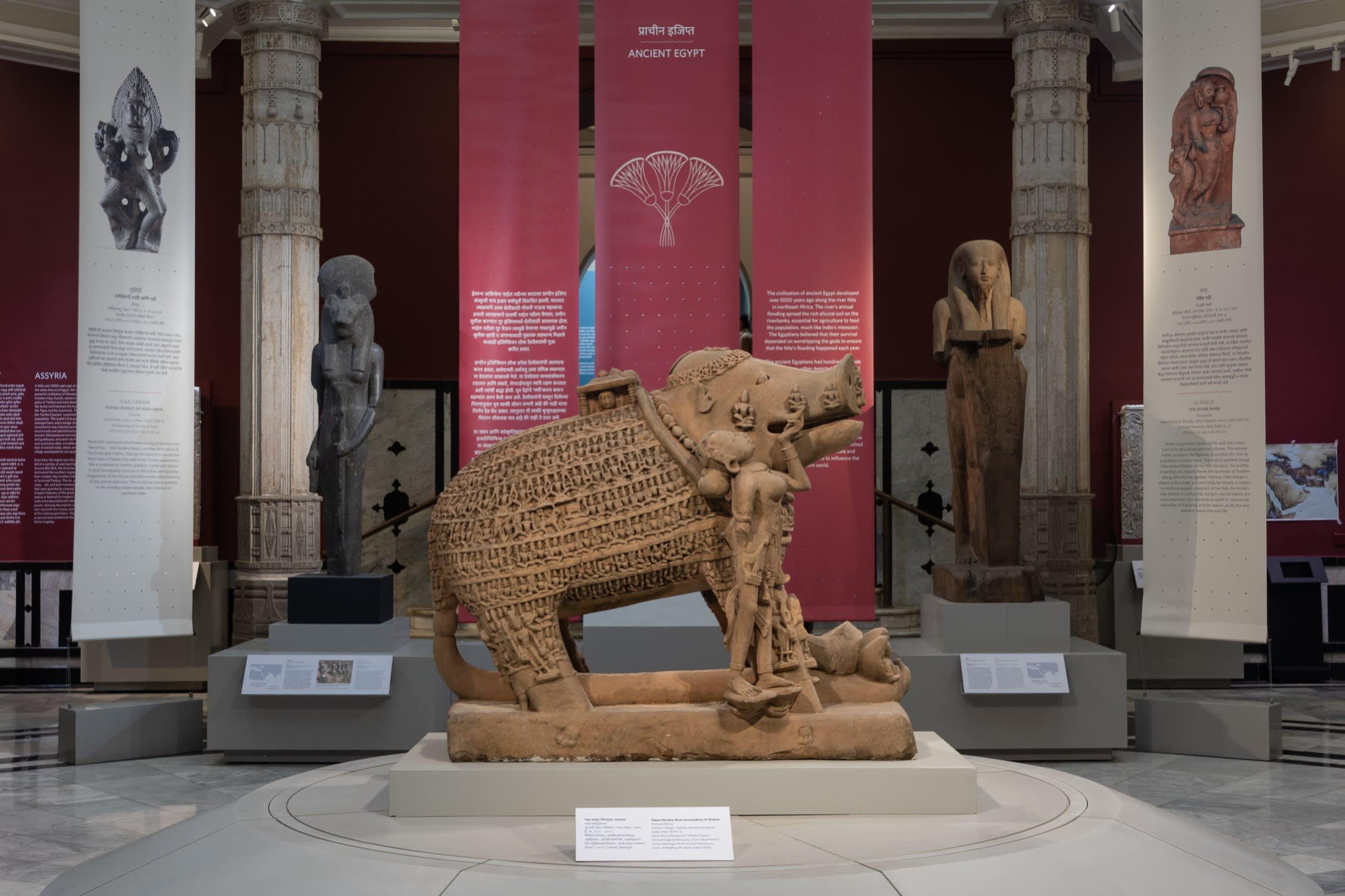 A stone sculpture of an elephant in a museum display room