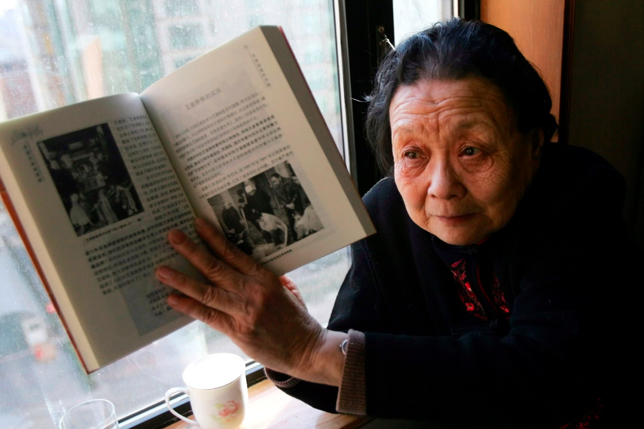 Gao displays a book she wrote about Aids in China, during an interview in Beijing in 2007. She moved to the US in 2009 and never returned to her homeland