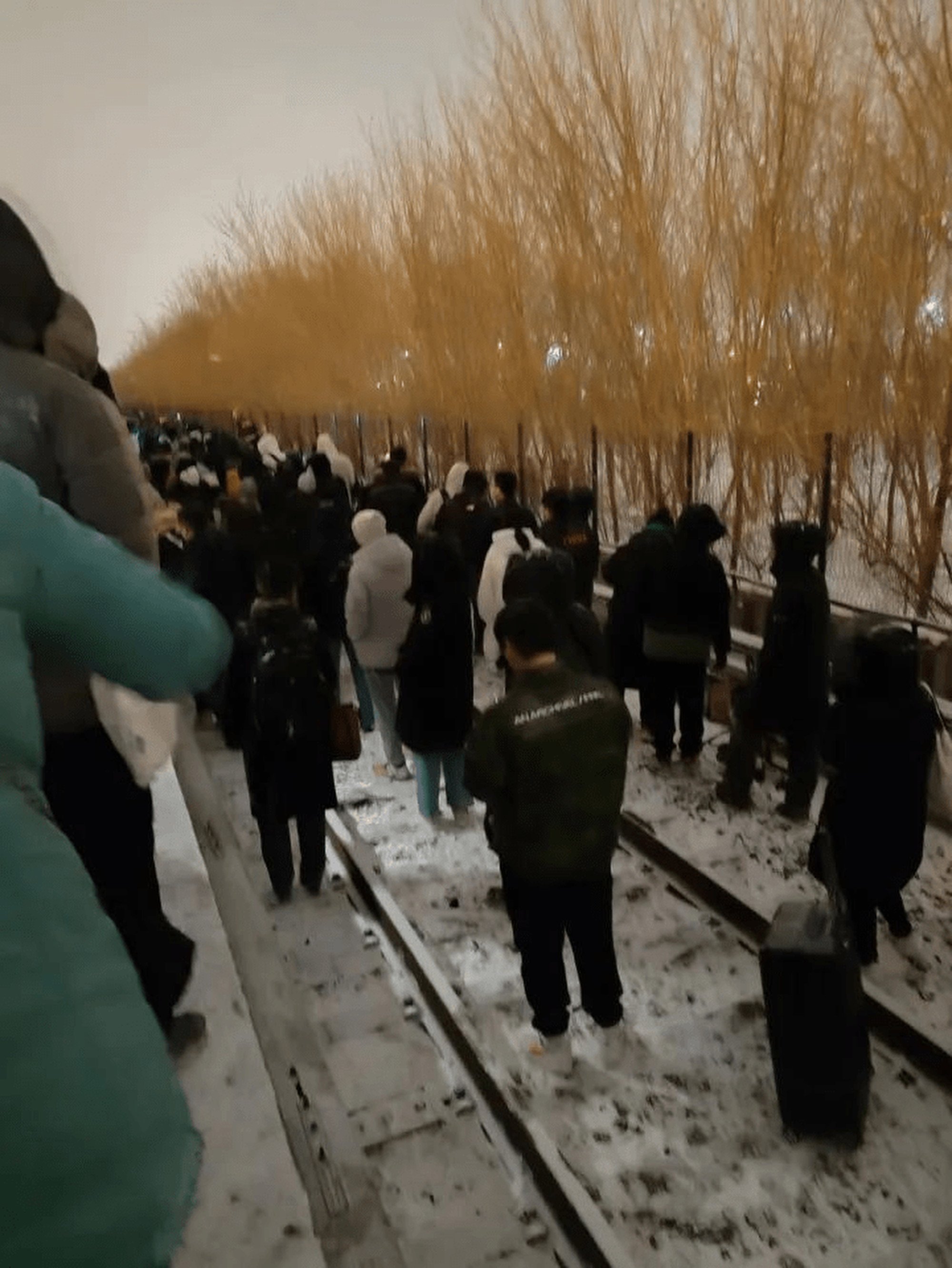 Passengers leave the damaged train and walk through the icy conditions in China’s capital Beijing on Thursday. Photo: Weibo