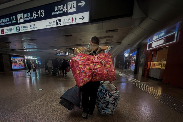 ENG_CHN_INTERVIEWSMigrantWorkers_12282023.4.jpg A Chinese migrant worker carries his belongings at the West Railway Station in Beijing, Jan. 6, 2023. (Wayne Zhang/AP)