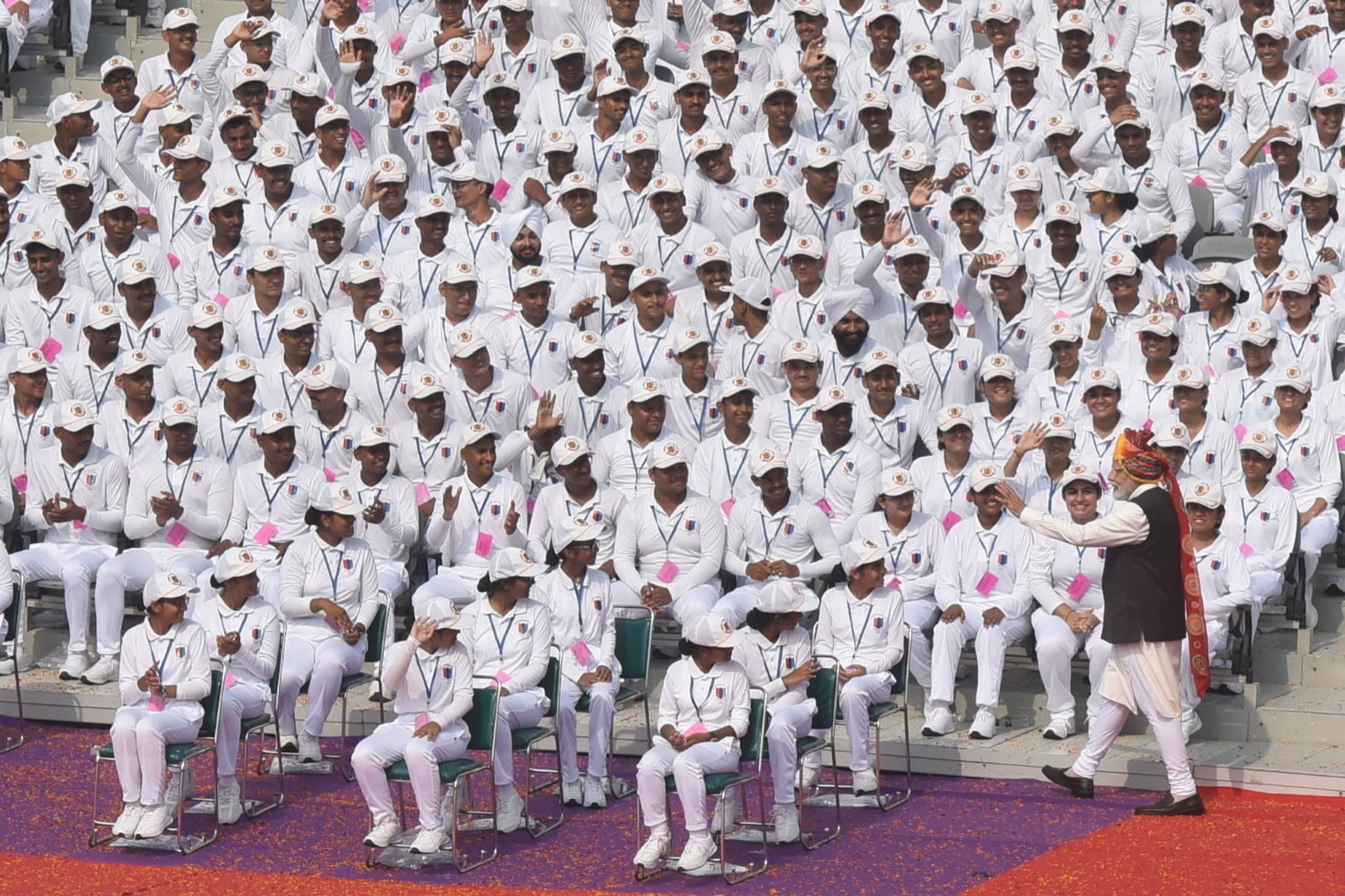 Officer cadets sit in neat rows in white uniforms