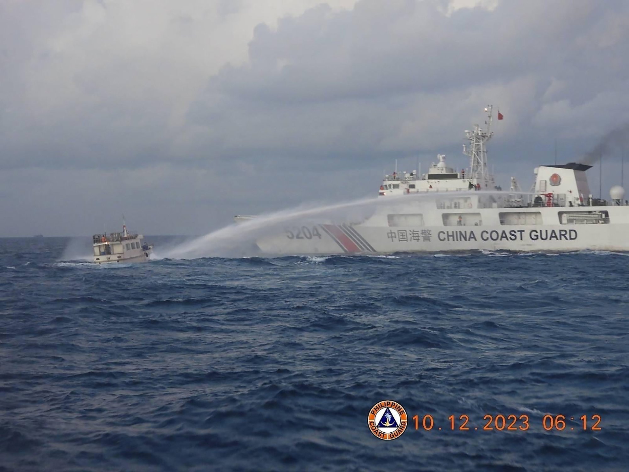 A China Coast Guard ship fires a water cannon at a supply boat operated by the Philippine Navy in the disputed South China Sea on December 10. Photo: EPA-EFE/Philippine Coast Guard /Handout