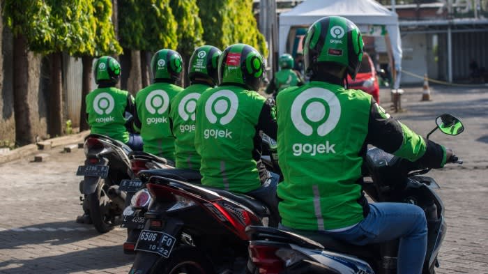 Gojek riders wait for their delivery orders at a distribution centre in Surabaya