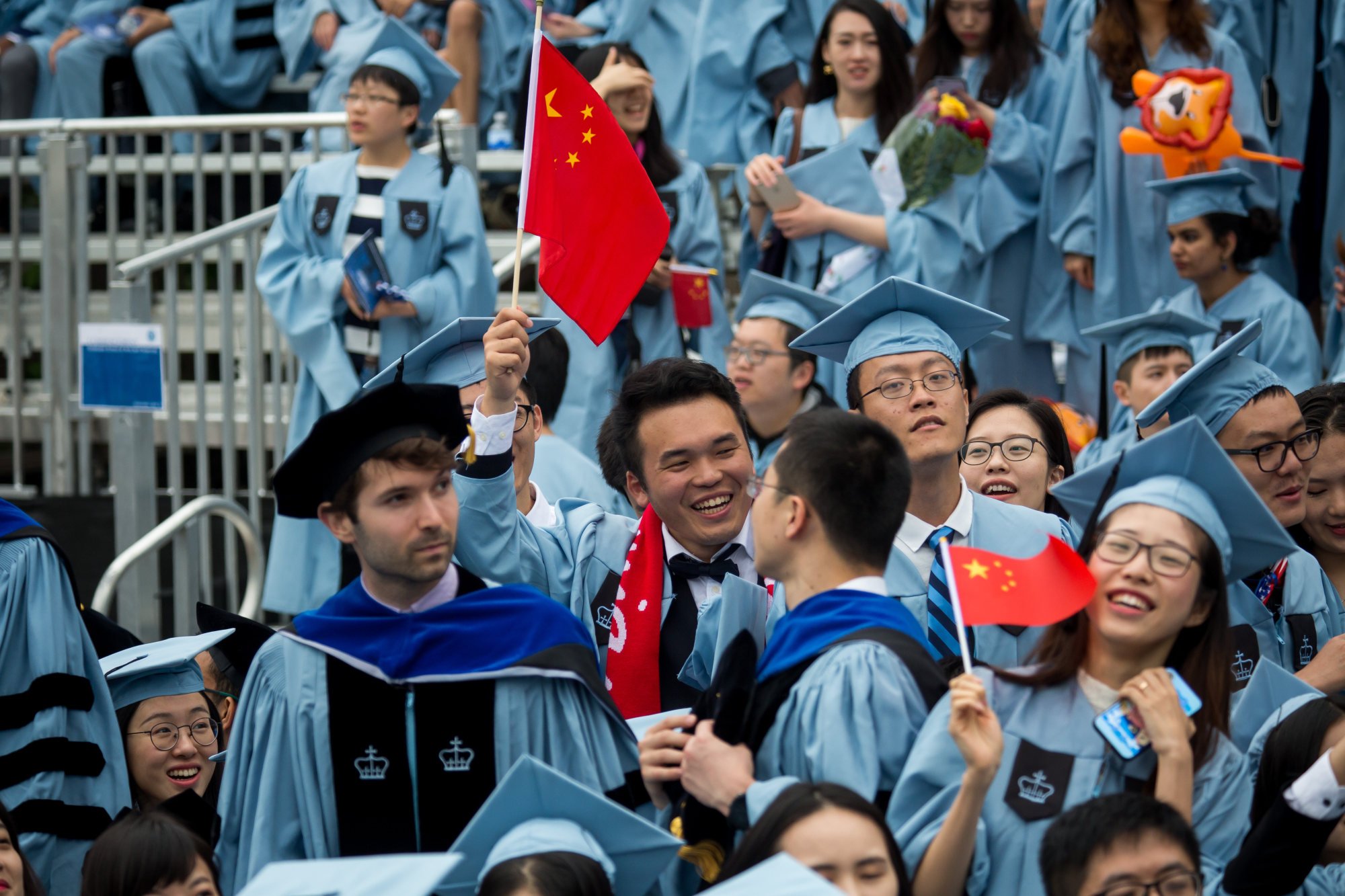 Chinese students wave flags at a ceremony at Columbia University in New York, US. But students are abandoning the previously popular country, as they increasingly choose instead to study abroad in Europe. Photo: Xinhua