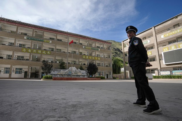 ENG_TIB_TibetanChildrenSupplementaryClasses_01082024.3.jpg A security guard stands watch at the Shangri-La Key Boarding School during a media-organized tour in Dabpa county, Kardze prefecture, southwestern China's Sichuan province, Sept. 5, 2023. (Andy Wong/AP)