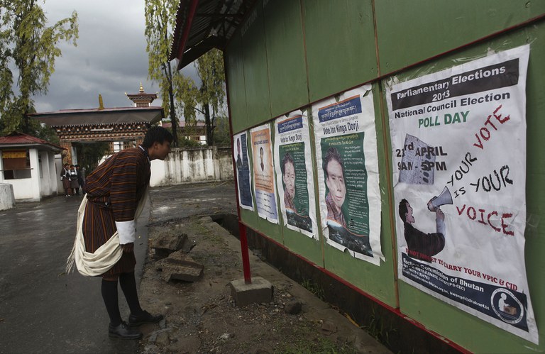 ENG_TIB_BhutanElectionsEconomy_01182024.4 (1).jpg A Bhutanese man looks at posters of candidates on the eve of polling to the upper house National Council in Samdrup Jonkhar, Bhutan, April 22, 2013. Bhutan ended more than a century of absolute monarchy with its first parliamentary elections in 2008. (Anupam Nath/AP)