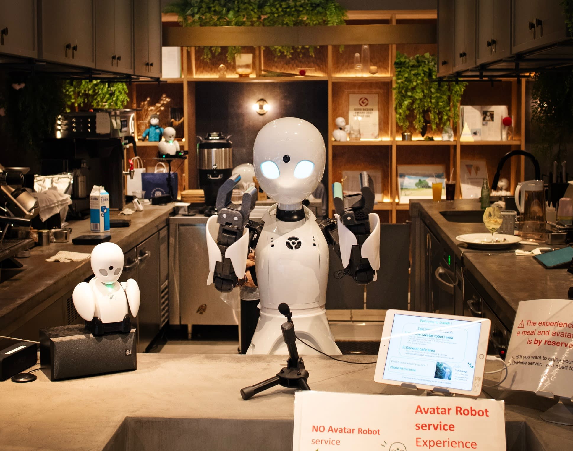 A humanoid robot with illuminated eyes behind the counter at Dawn Avatar Robot Café