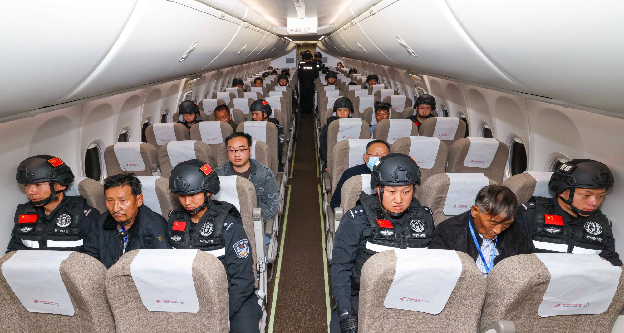 The cyber fraud suspects are escorted by Chinese police on a charter flight from Myanmar to China on Tuesday. Photo: Xinhua