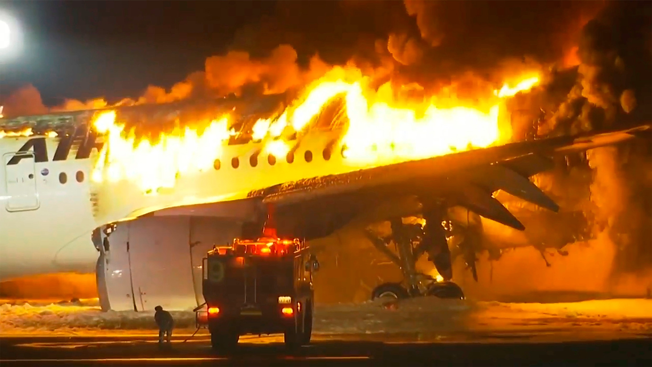 The Japan Airlines aircraft on fire after the crash at Tokyo's Haneda Airport