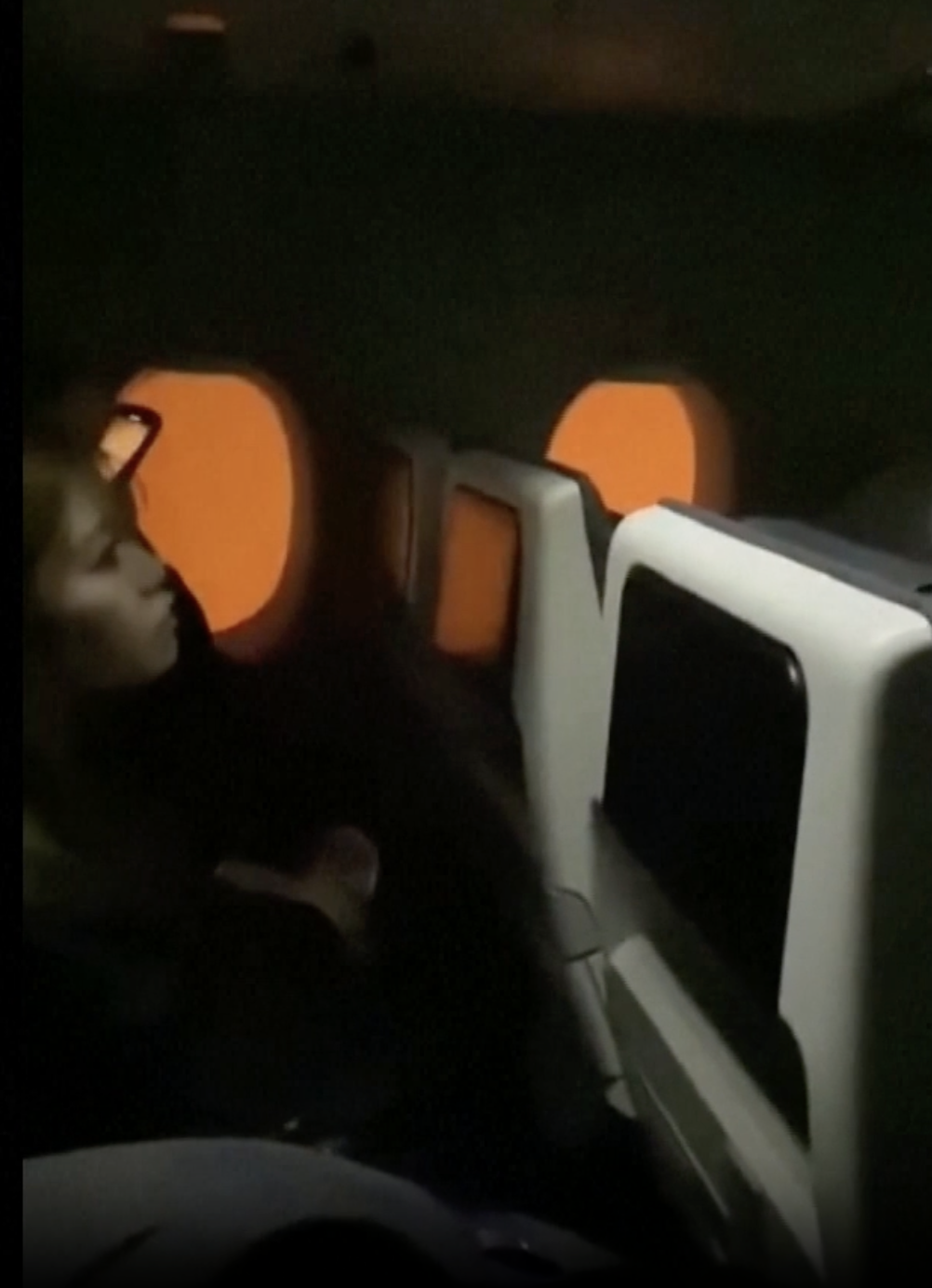 Panicked passengers inside the Japan Airlines aircraft are evacuated by the flight crew