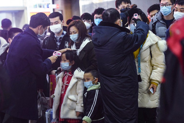 ENG_CHN_LockdownAnniversary_01242024.2.jpg Staff members check the temperatures of passengers arriving on a train from Wuhan to Hangzhou, China, Jan. 23, 2020. (AFP)