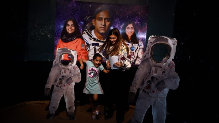 A mother and her daughter arrive at Nehru Planetarium in New Delhi to watch India’s Moon landing