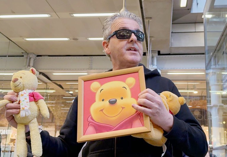 ENG_CHN_UKPiano_01292024_3.JPG YouTuber Brendan Kavanagh holds up a Winnie the Pooh doll, which is banned in China, after playing the public piano at London's St. Pancras railway station on Jan. 26, 2024. (RFA)
