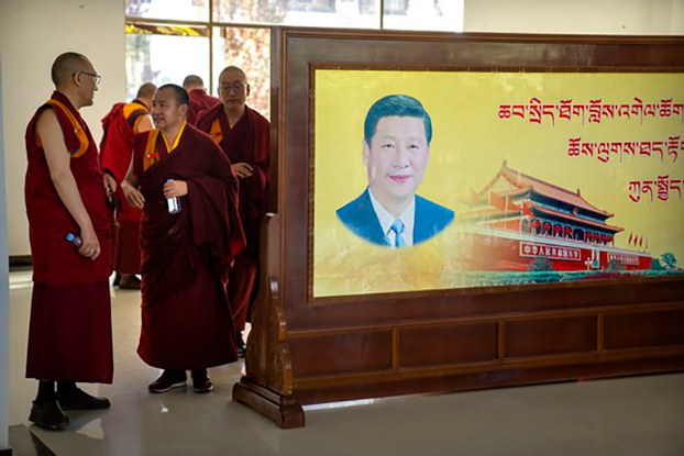 ENG_TIB_TibetanMonasteryMonksAdmission_01022024.jpg Monks stand near a mural featuring Chinese President Xi Jinping at the Tibet Autonomous Region Buddhist College near Lhasa in western China's Tibet Autonomous Region, May 31, 2021. (Mark Schiefelbein/AP)