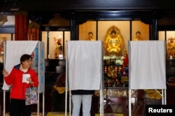 A woman prepares to cast her ballot at a polling station during the presidential and parliamentary elections in Taipei, Taiwan, on Jan. 13, 2024.