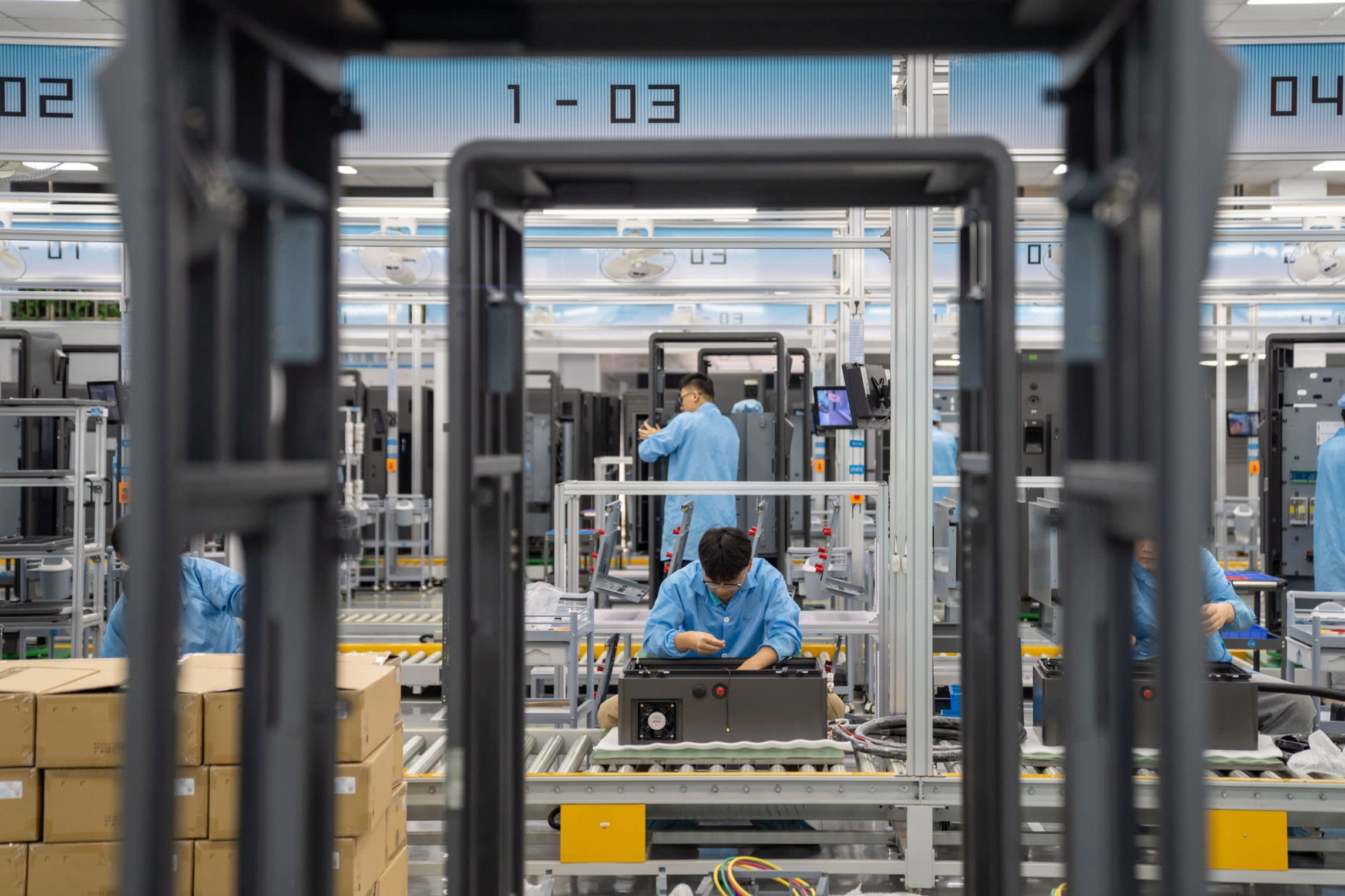 Technicians assemble DC charging piles for electric vehicles at a workshop in China