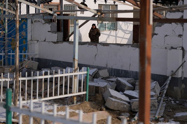 ENG_UYG_AksuEarthquake_01242024.4.jpg Nurahun Osman walks near a collapsed wall damaged by the earthquake in Yamansu township, Aksu prefecture, in northwestern China's Xinjiang region, Jan. 24, 2024. (Ng Han Guan/AP)