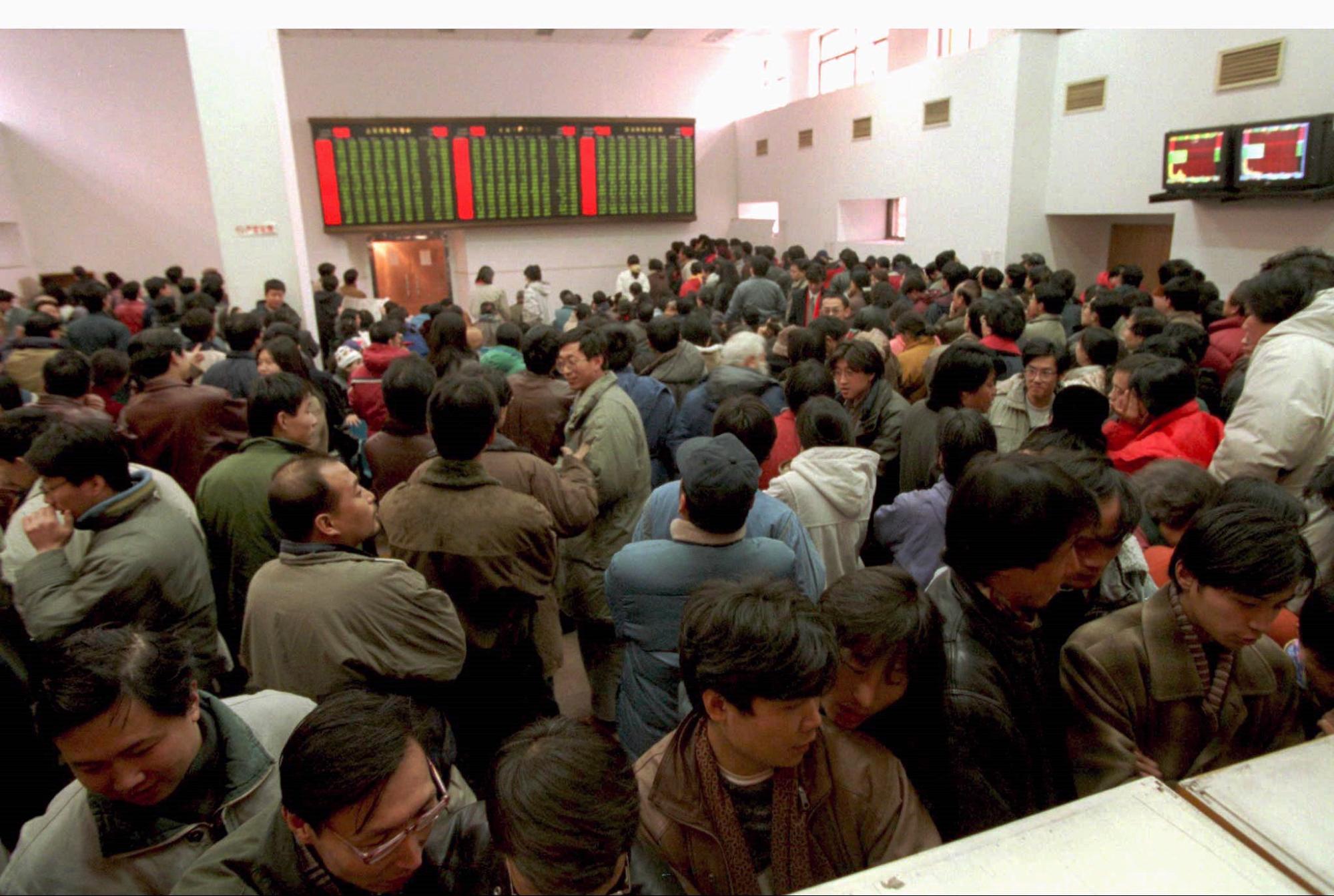 Retail investors and stock punters thronged the trading hall of a brokerage firm in western Beijing on December 16, 1996. Contrary to global convention, China’s stock market denotes losses in green and uses the red colour to represent gains and profits. Photo: Reuters