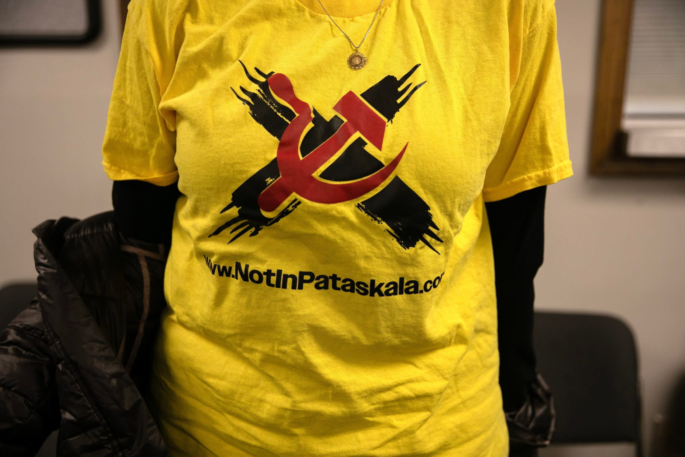 A person wears a t-shirt with a Not in Pataskala logo with an X behind a red hammer and sickle