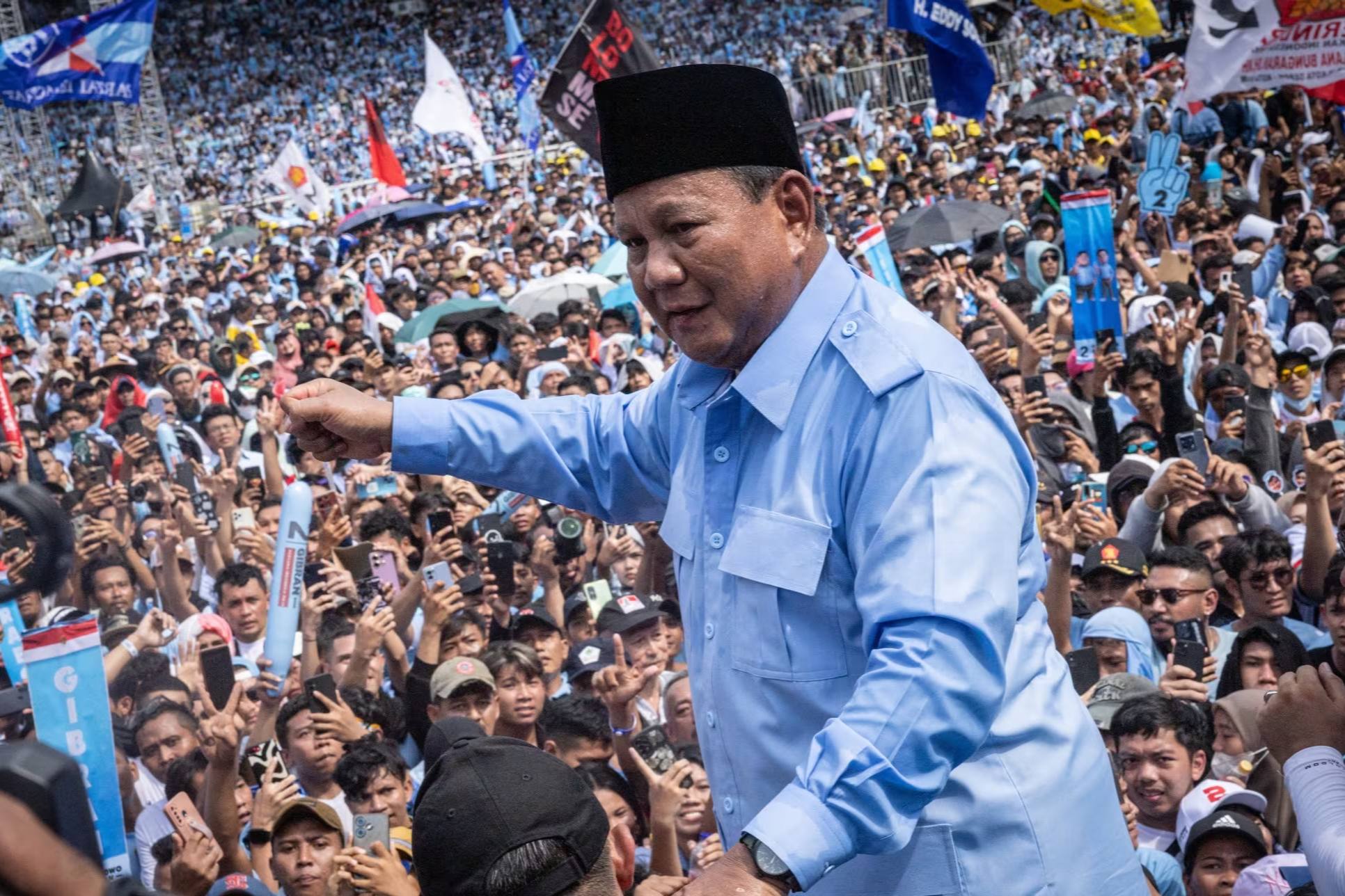 Prabowo Subianto standing above a crowd of people at a rally