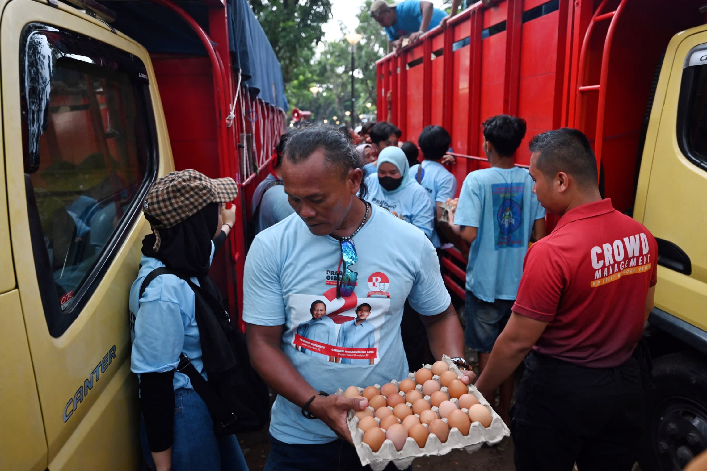 Supporters of presidential candidate Prabowo Subianto and vice presidential candidate Gibran Rakabuming Raka receive free eggs after an election campaign rally in Jakarta on Saturday
