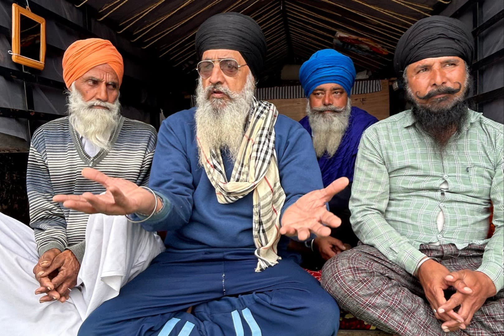 Juzhar Singh, in a blue tracksuit, with fellow farmers
