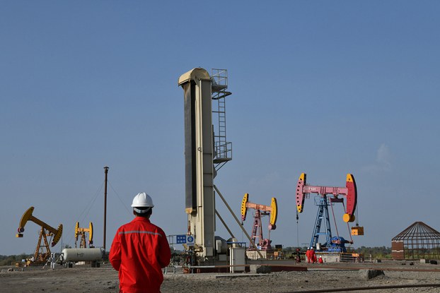 ENG_CHN_INTERVIEWFrankDikotter_02222024.3.jpg Workers are seen near pumpjacks at a China National Petroleum Corp oil field in Bayingol in northwestern China’s Xinjiang region, Aug. 7, 2019. (Reuters)