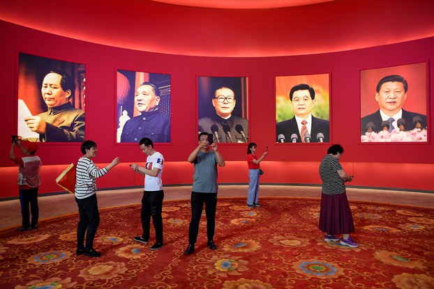 ENG_CHN_INTERVIEWFrankDikotter_02222024.2.jpg People take pictures in front of portraits of, from left, the late Chinese chairman Mao Zedong and former Chinese leaders Deng Xiaoping, Jiang Zemin, Hu Jintao and current president Xi Jinping at an exhibition in Beijing, Sept. 26, 2019. (Wang Zhao/AFP)