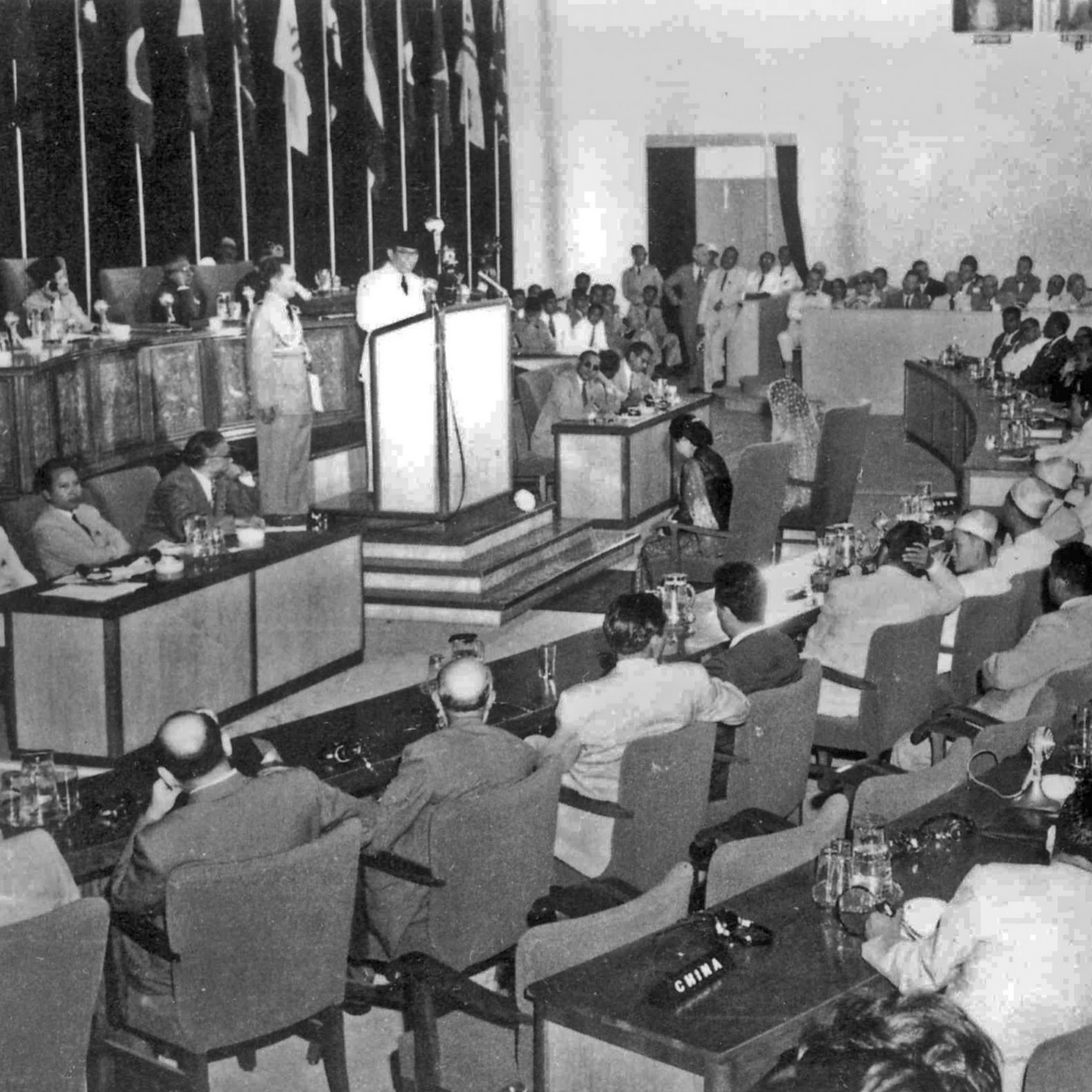 A man speaks at a lectern in a conference room