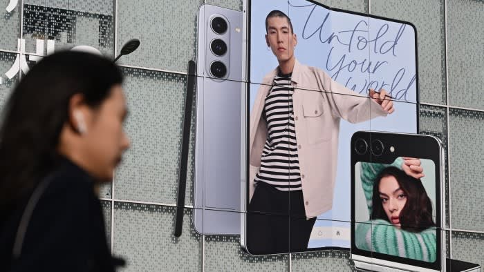 A woman walks past an advertisement for the Samsung Galaxy Z Fold5