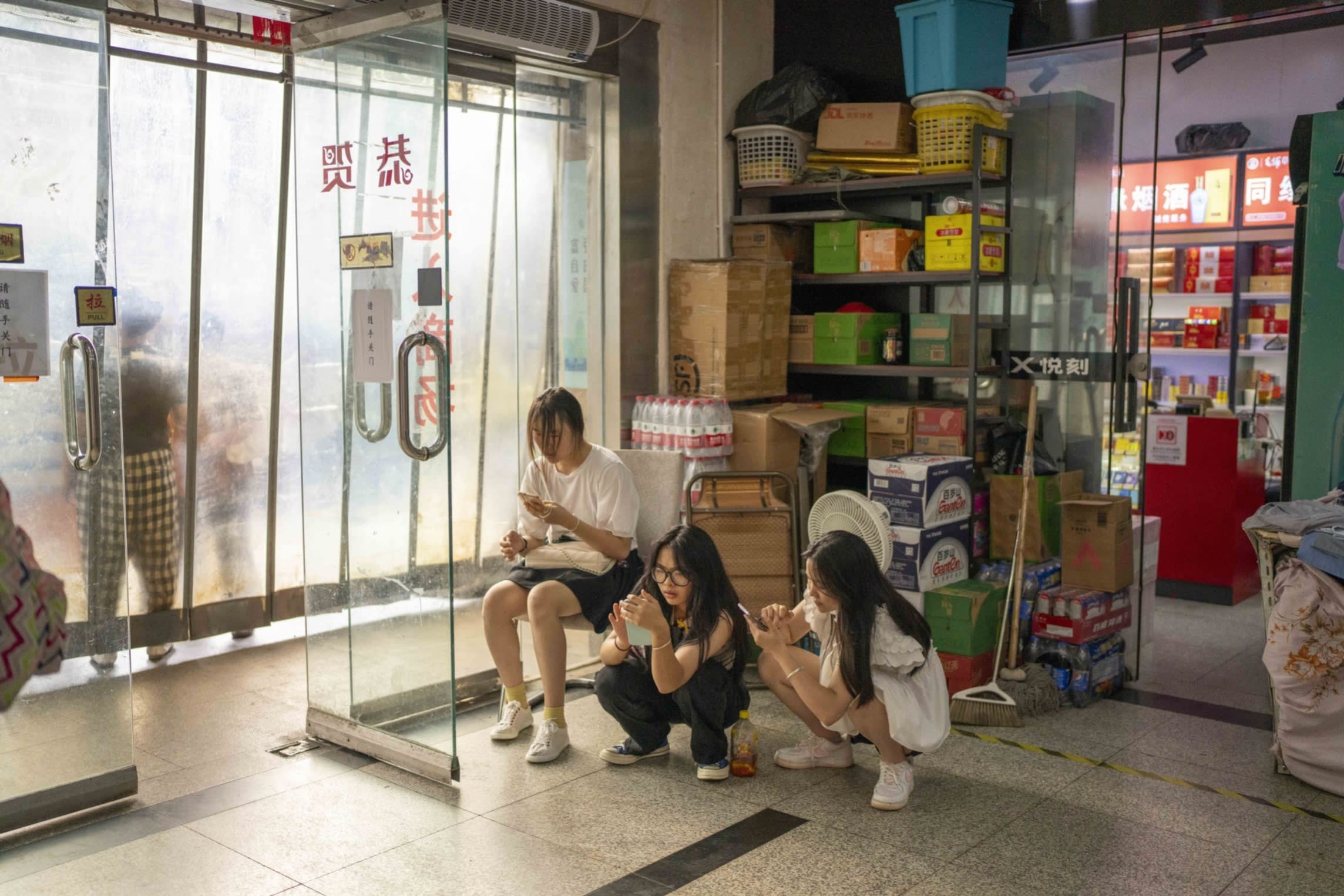 Pedestrians wait by a store in Shanghai