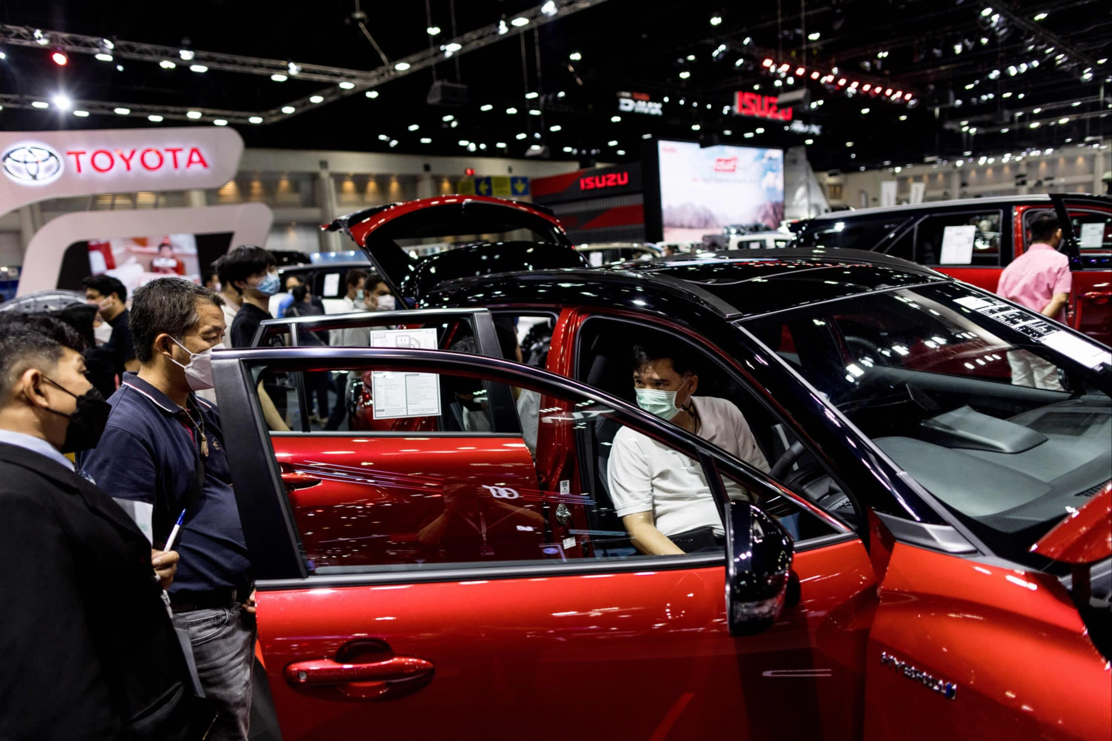 Visitors examine Toyota’s Corolla Cross HEV GR Sport hybrid at a motor show