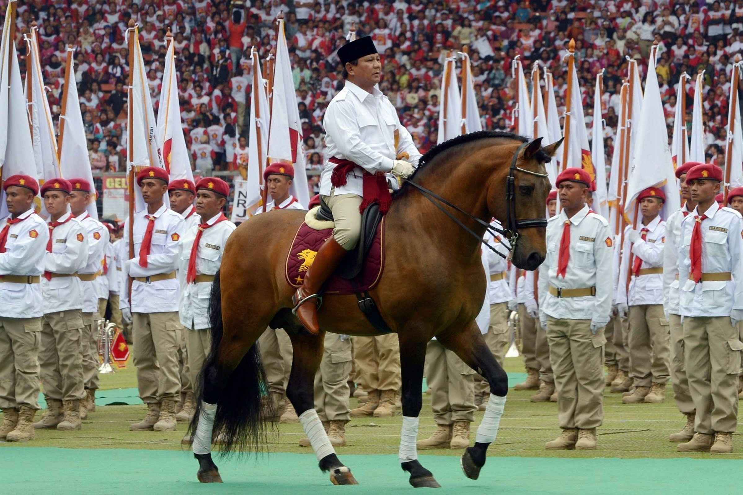 Prabowo Subianto parades on horseback as he inspects a roll call at a campaign event in Jakarta in 2014