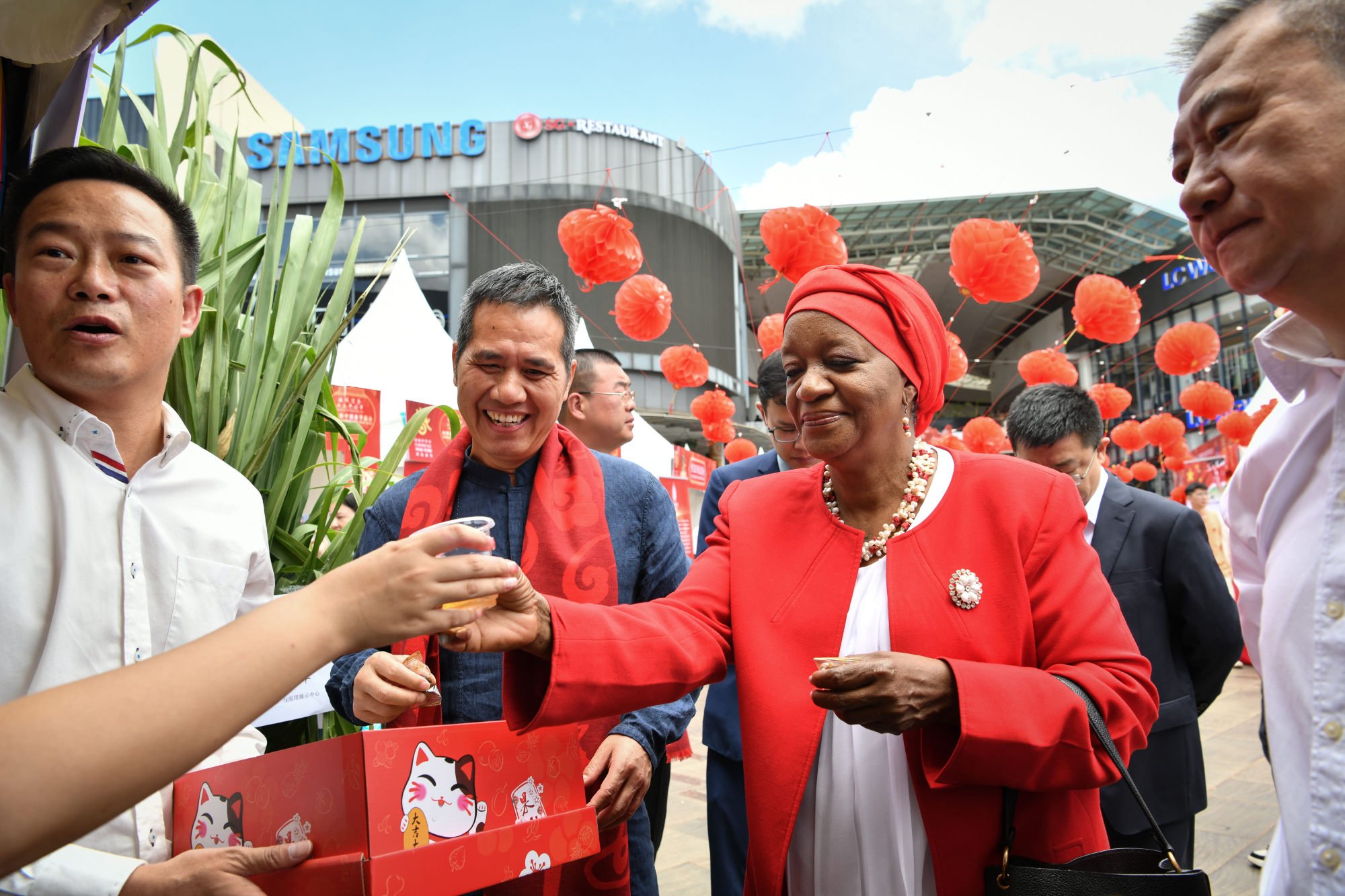 Zainab Hawa Bangura samples a drink as Zhou Pingjian (second left) looks on, at the Nairobi gala to ring in the Year of the Dragon. Photo: Xinhua