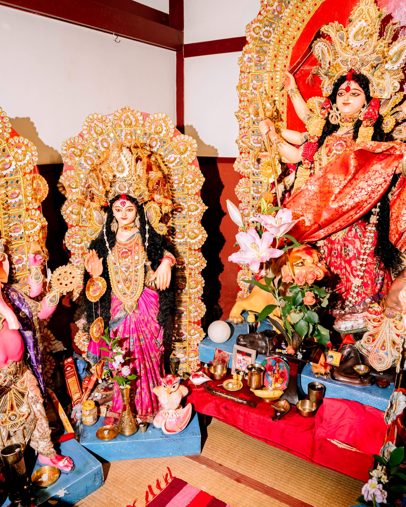 Colourful statuettes of female Hindu deities in a corner of Puja