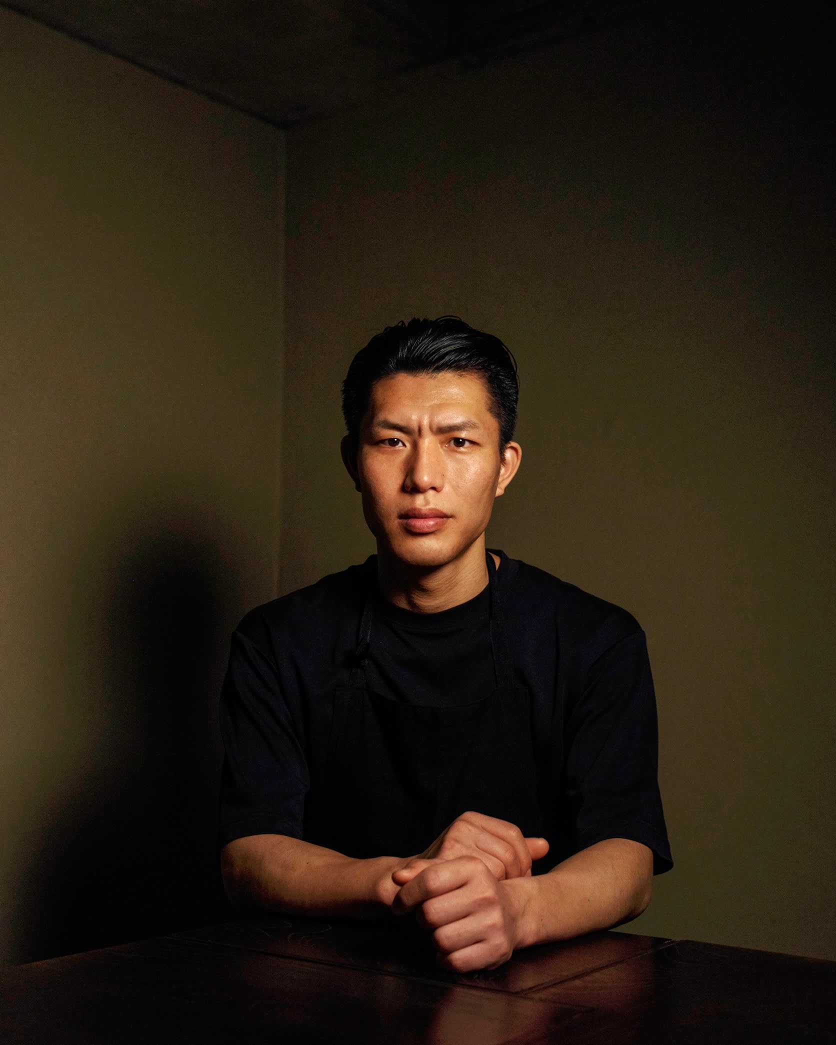 Takamasa Osawa of Biryani Osawa sitting at a table with his hands folded