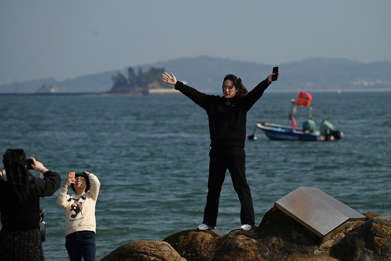 ENG_WOMEN'S_Analysis_03072024.4.jpg A woman poses on the beach in Xiamen in China’s Fujian province on Jan. 10, 2024. (Greg Baker/AFP)