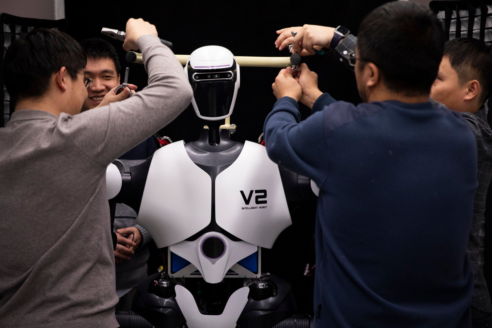 Chinese researchers adjust a humanoid robot at an AI laboratory in Beijing. Photo: Xinhua
