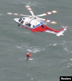 A helicopter conducts a search and rescue operation after Keoyoung Sun, a South Korean chemical tanker capsized off the western Japan city of Shimonoseki, Yamaguchi Prefecture in western Japan, March 20, 2024, in this photo taken by Kyodo.