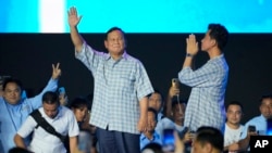 FILE - Indonesian presidential candidate Prabowo Subianto, left, and his running mate Gibran Rakabuming Raka, the eldest son of Indonesian President Joko Widodo, greet supporters during a gathering in Jakarta, Feb. 14, 2024.