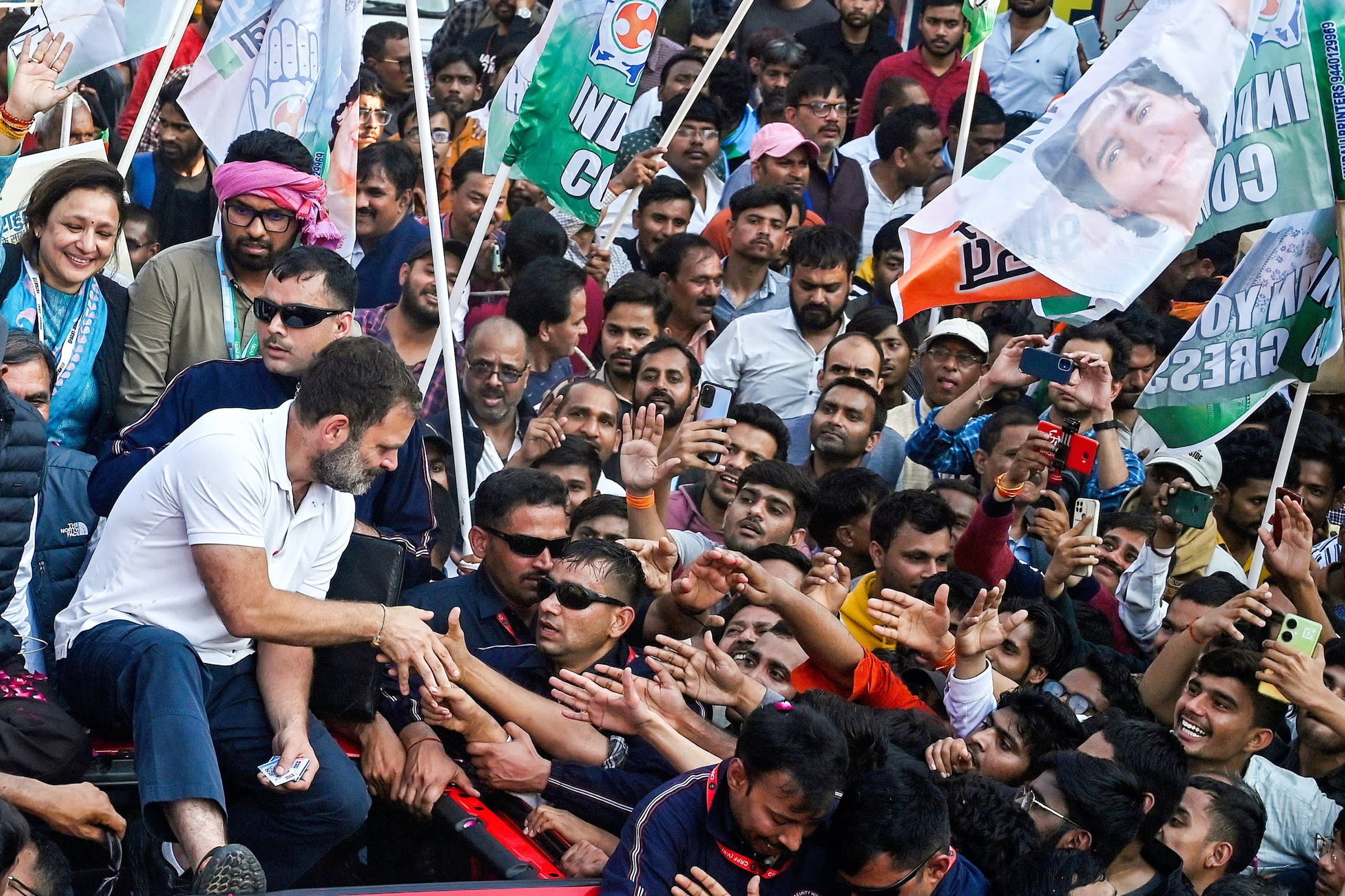 People reach out to shake Gandhi’s hand as the jeep makes its way through a crowd